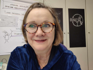 Frau in blauem Kleid mit Brille