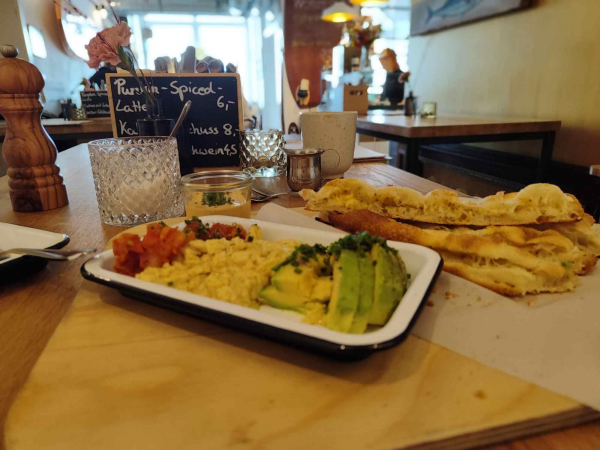 Frühstück mit Rührei und Avocado in modernem Café
