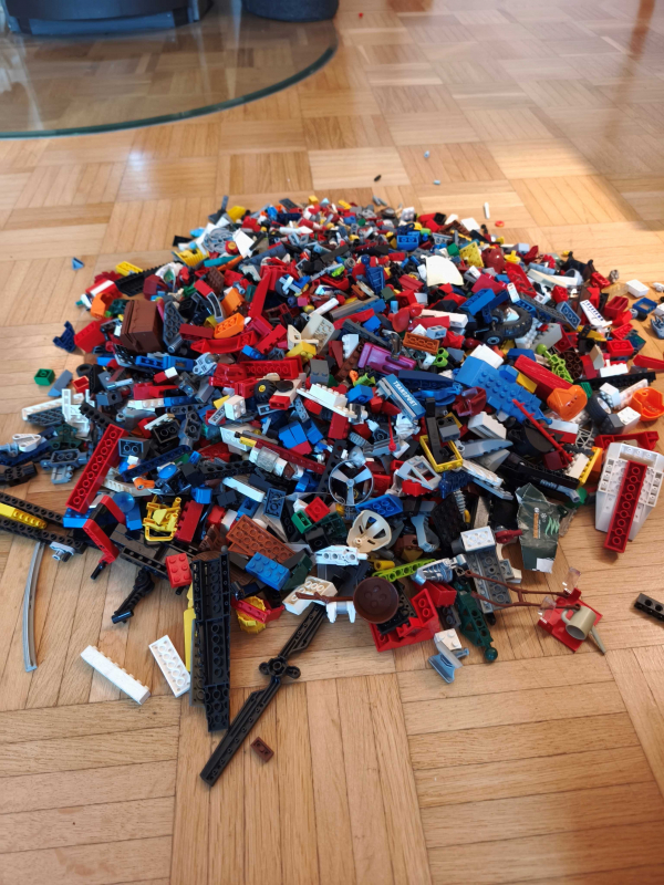 Haufen Lego®Steine auf Parkett ausgeschüttet.